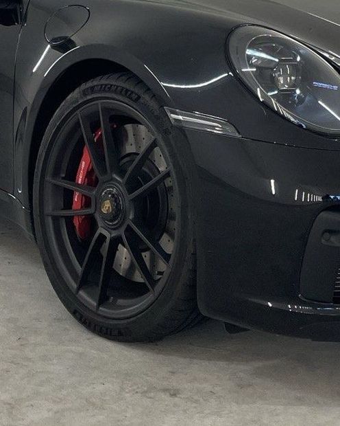 Vorderrad und Scheinwerfer eines schwarzen Porsche 911 Targa